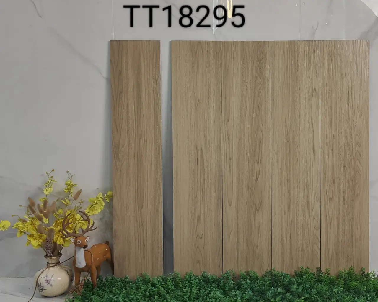 Wood look ceramic tiles in beige tones displayed with a small deer figurine and yellow flowers.