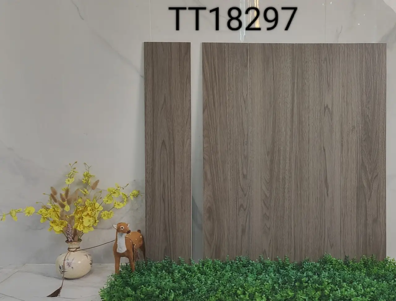 Two grey wood-grain ceramic tiles displayed against a wall with a vase and figurine.