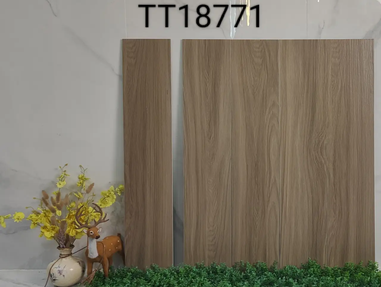 Two wood-look floor tiles standing upright against a wall, with decorative props.
