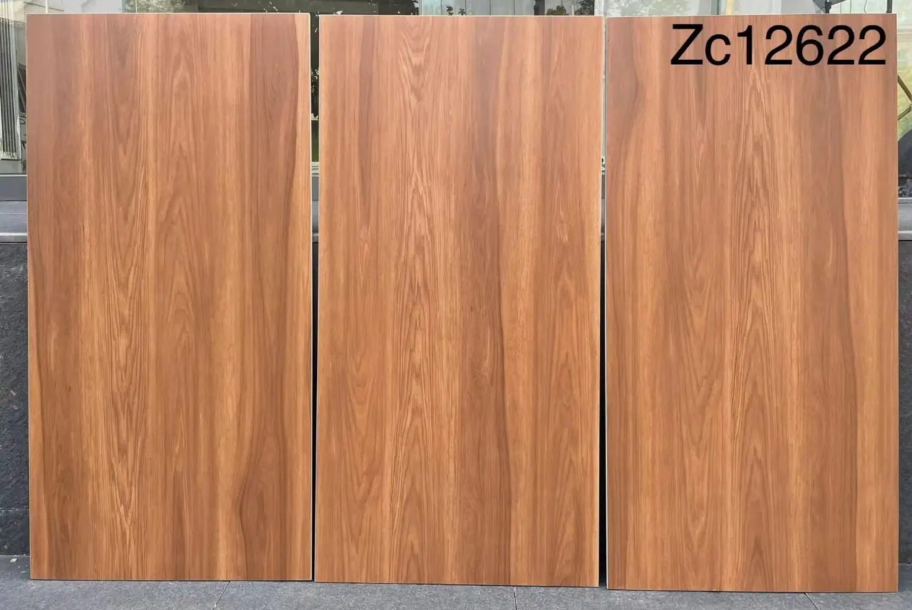 Three wood-grain ceramic tiles standing upright on a ledge.