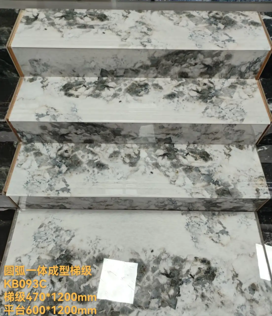 Stacked white and grey marble stair treads with veining, showing a sample of stone steps.