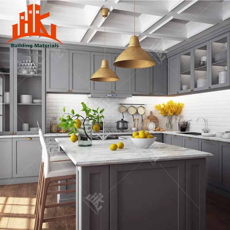 Modern kitchen with grey cabinets, white subway tile, marble island, and brass pendant lights.
