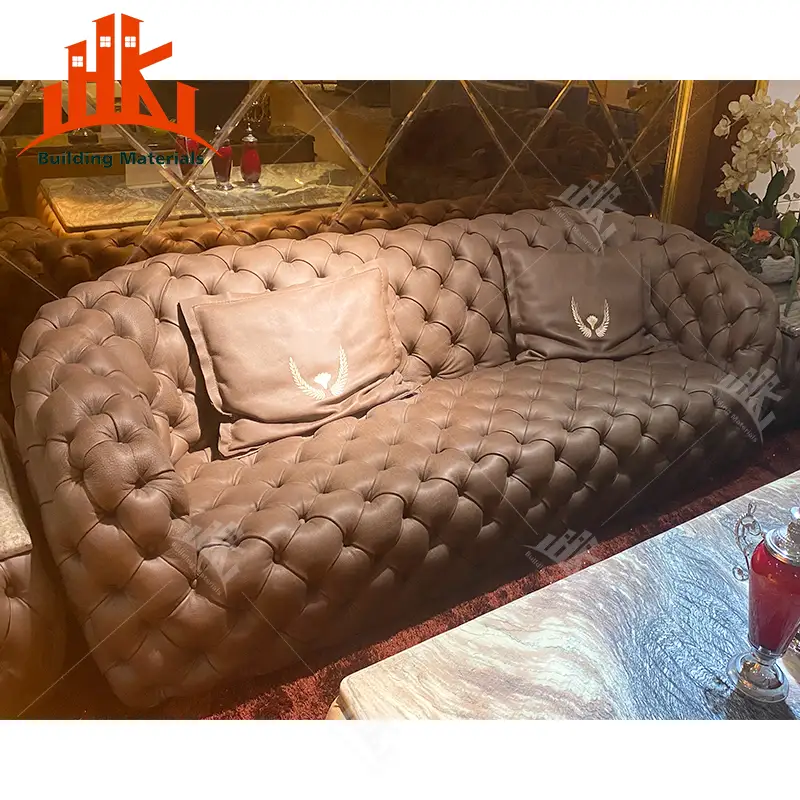 A brown tufted leather sofa with matching cushions in a furnished room.