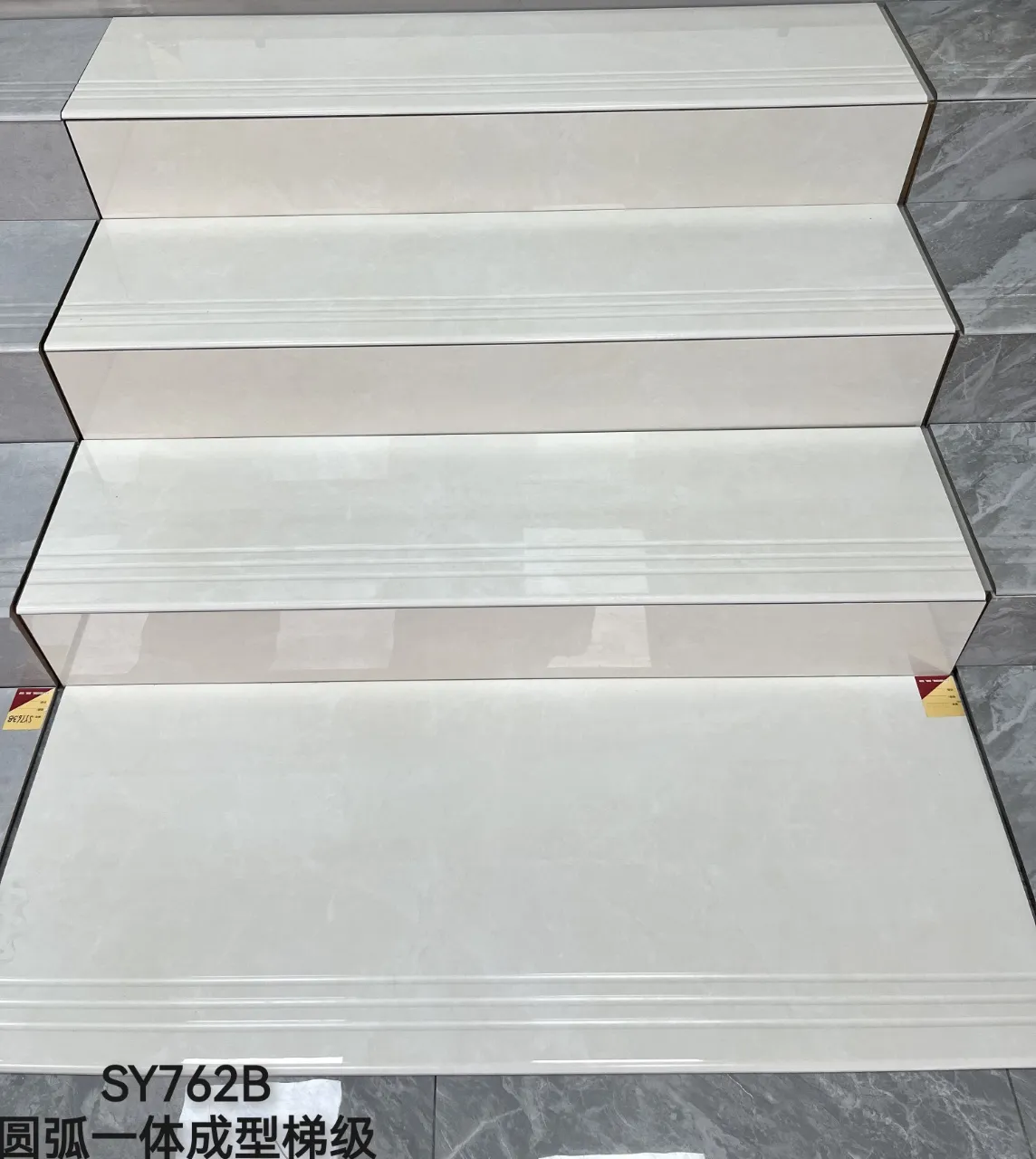Stack of white glazed porcelain stair treads with rounded nosing and anti-slip grooves.