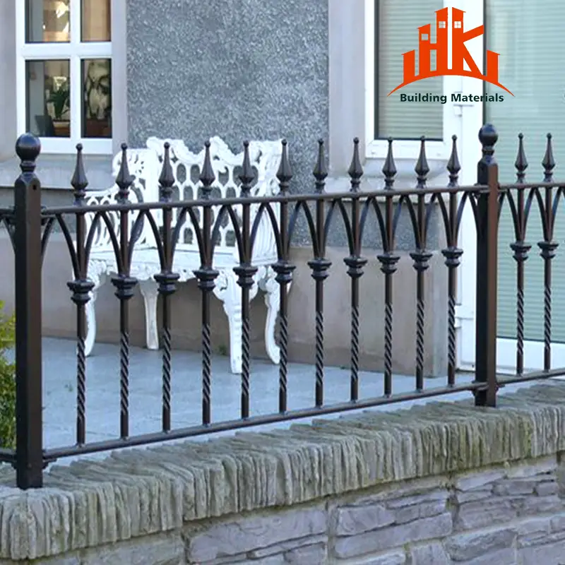 Black ornamental iron railing with spear tips installed on a stone wall