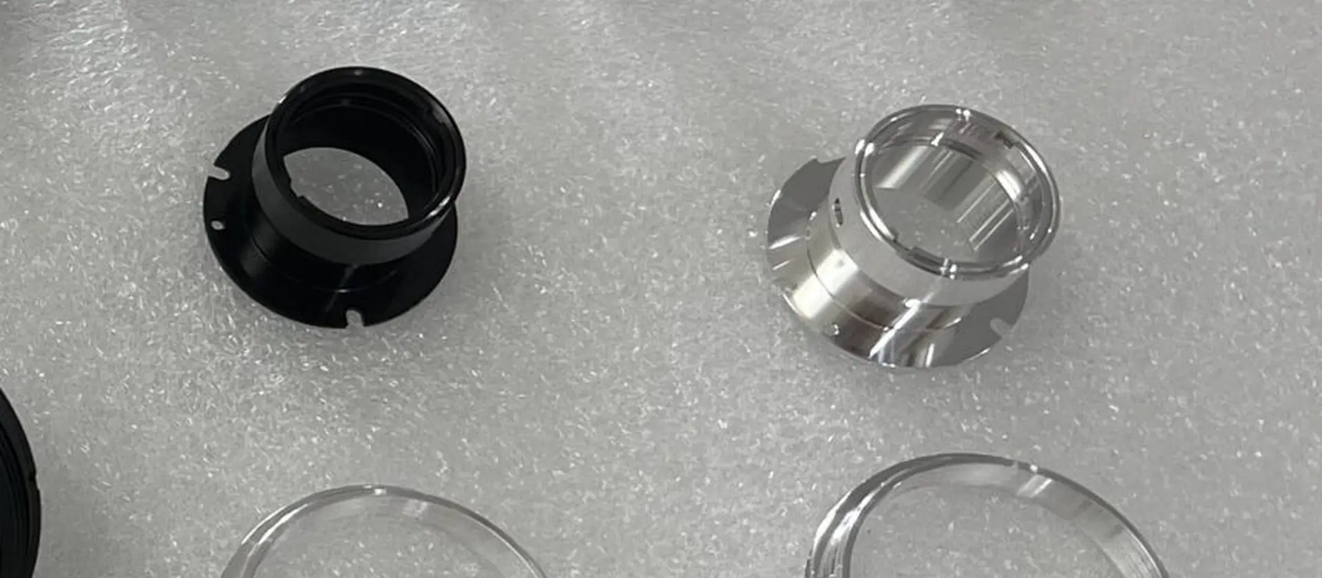 Machined aluminium tube clamps connectors and retaining rings arranged on a work surface