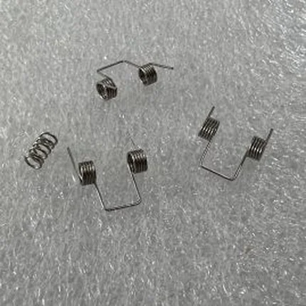 Group of stainless steel torsion springs and wire forms with formed legs