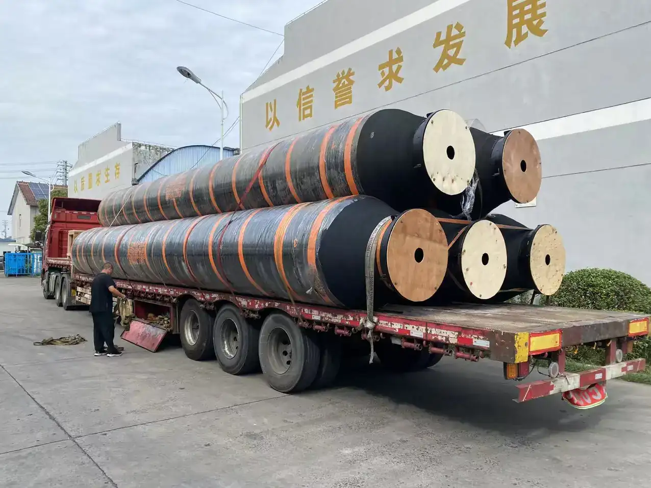 Large dredging hoses strapped to a flatbed trailer for despatch from the East Marine factory