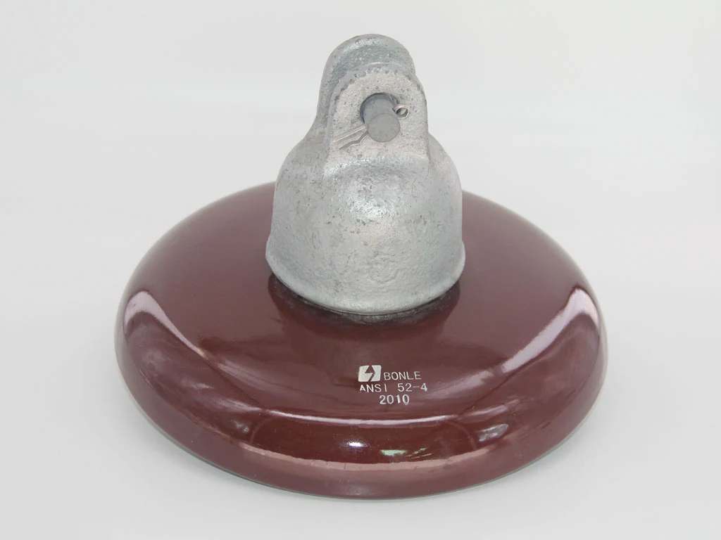 Close-up of a brown porcelain electrical insulator with a metal cap and eyelet.
