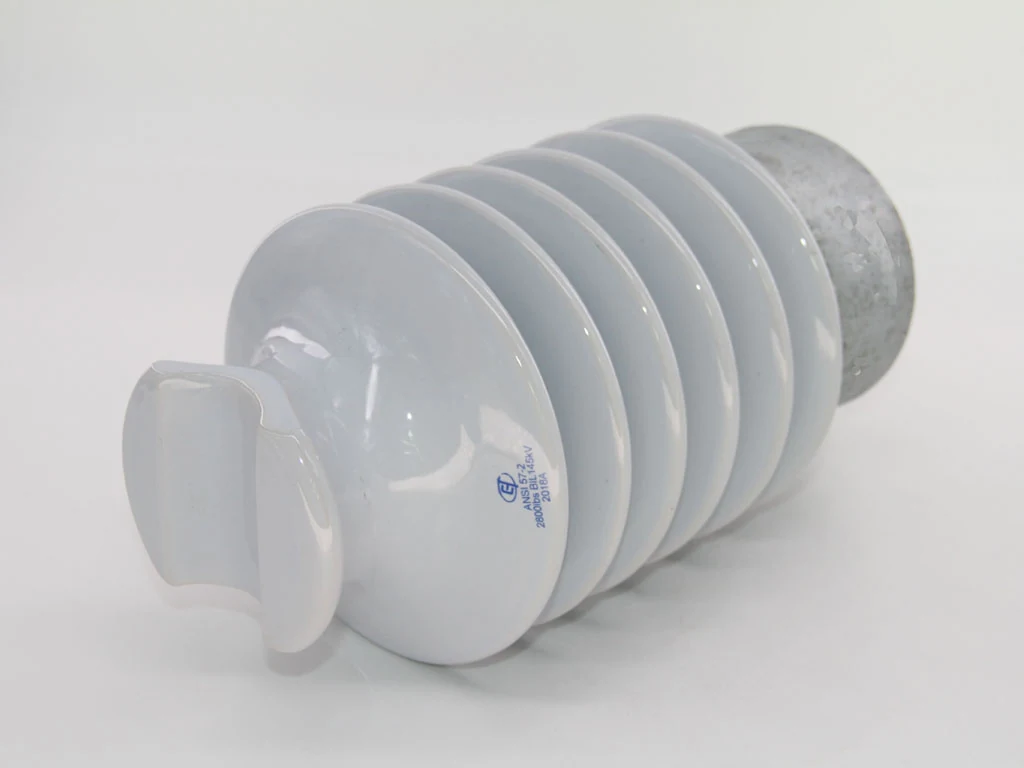 A white ribbed ceramic electrical insulator with a metal cap on a white background.