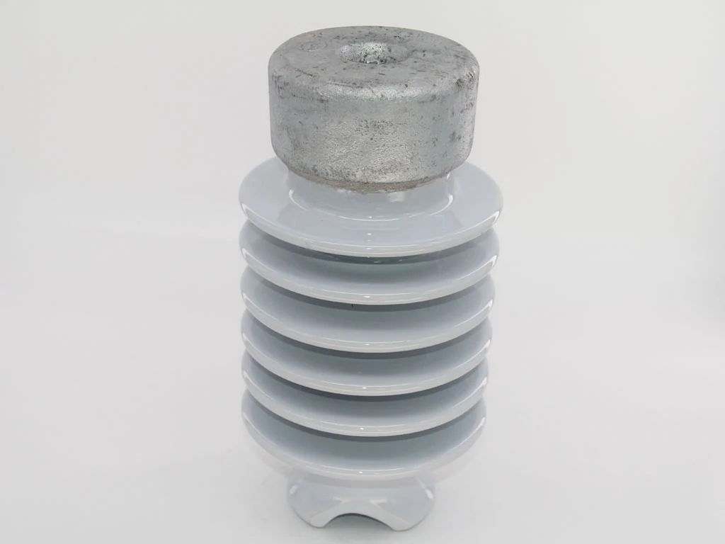 White porcelain insulator with stacked sheds and galvanized metal cap, centered on a plain light background