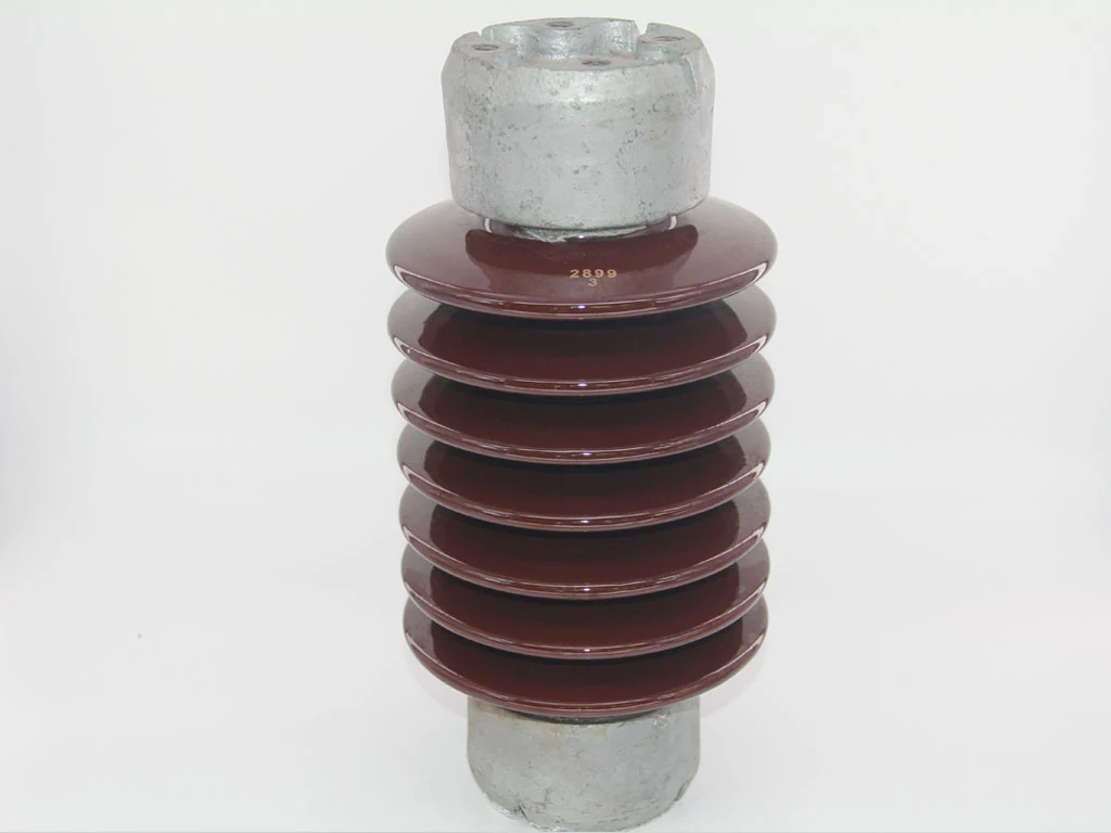 Brown glazed ceramic electrical insulator with ribbed sheds and galvanized metal end fittings on a white background
