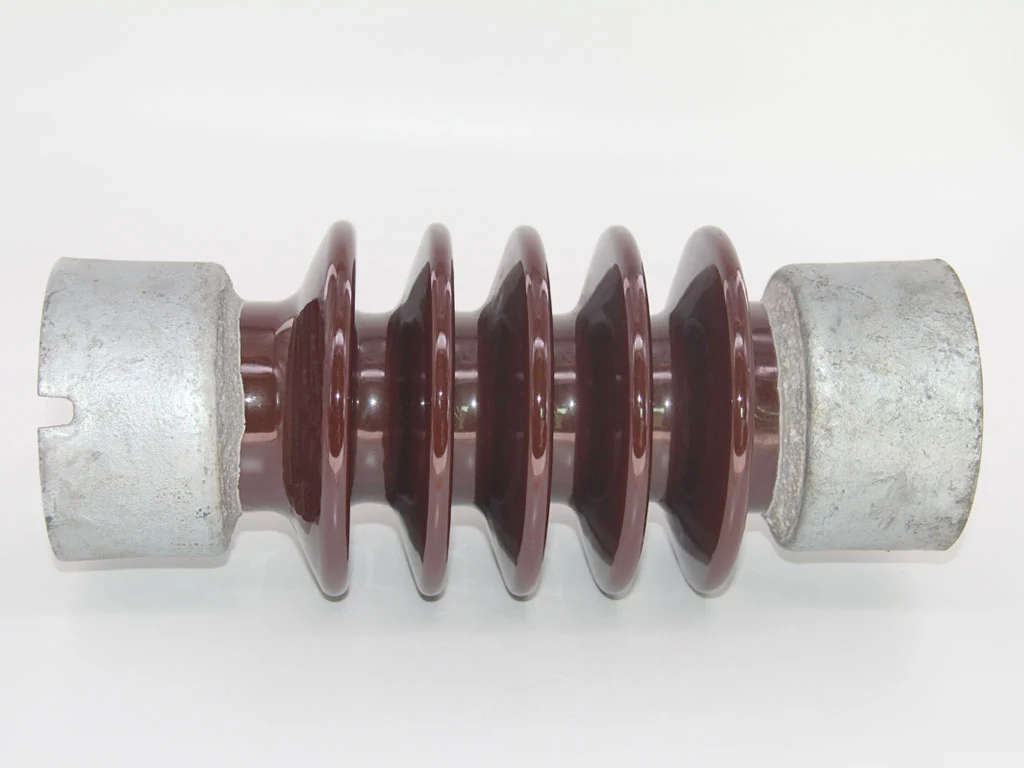 Brown porcelain electrical insulator with ribbed sheds and galvanized metal end fittings on a white background