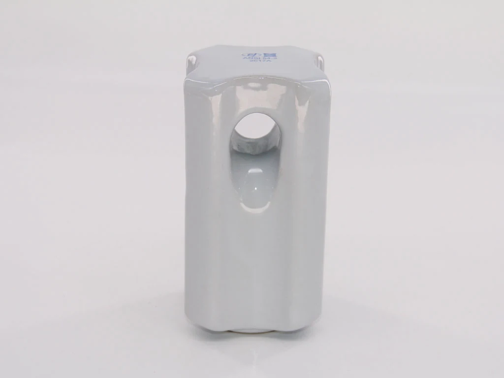 A white, rectangular plastic component with a circular hole and a small blue marking on top.