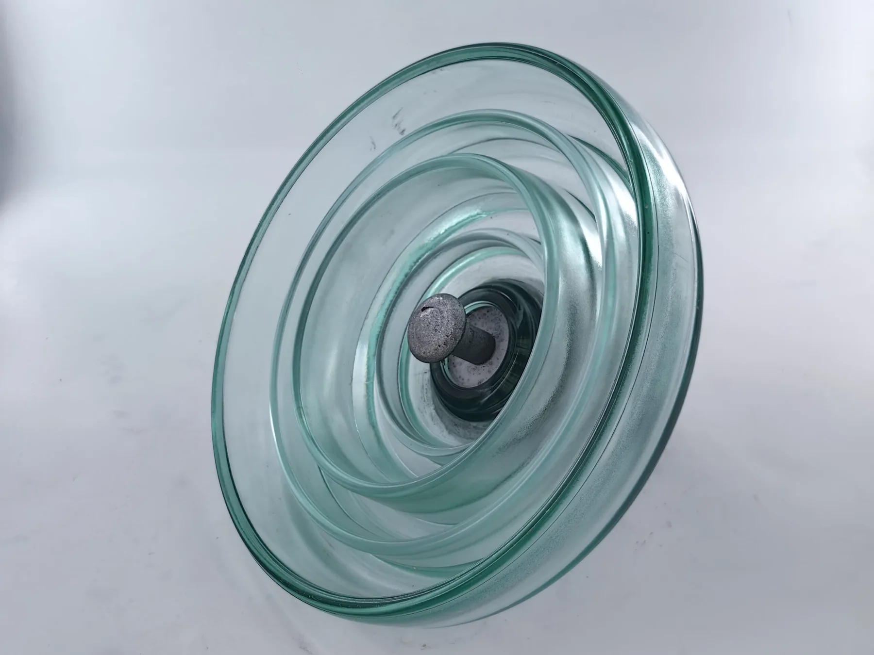 Underside of a toughened glass suspension insulator showing deep anti-pollution sheds