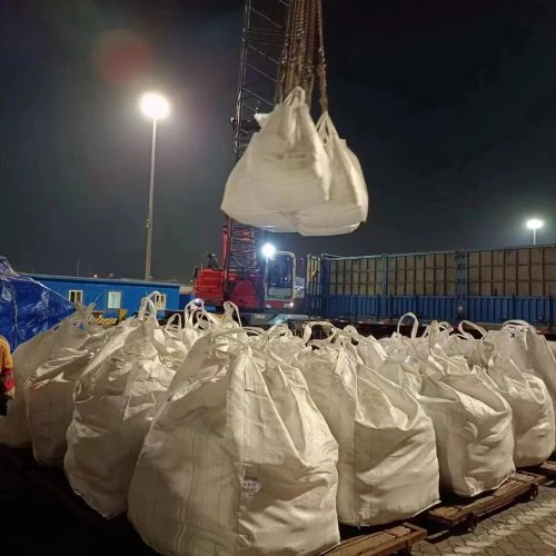 Bulk bags being loaded into a container at port at night