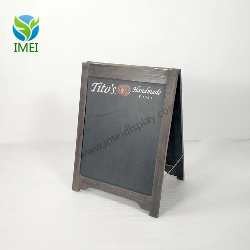 Wooden A-frame chalkboard standing open on a workshop floor