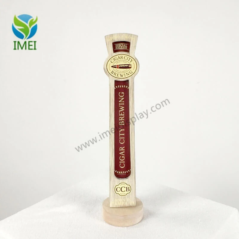 Custom wood tap handle with laser-cut branding and engraved logo on a workshop table
