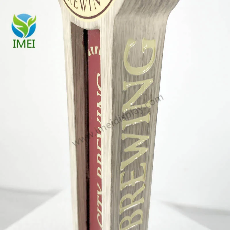 Close-up of a wood tap handle showing engraved text and natural grain finish