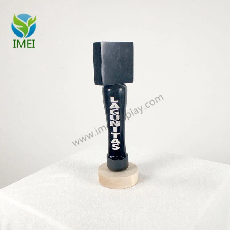 Close-up of a custom wooden tap handle with black finish and branded logo