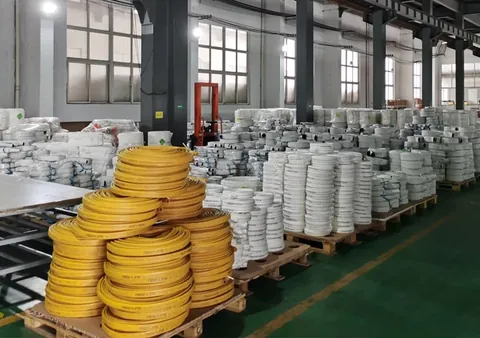 Coiled hose on pallets awaiting dispatch, colour separated by product and order.