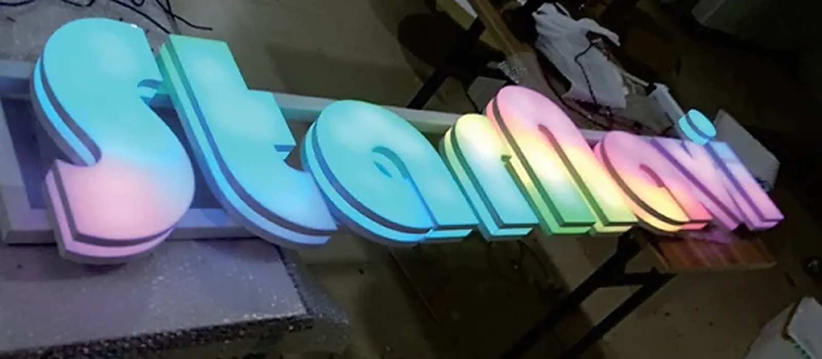 Built-up channel letters lit in colour by RGBW LED sign modules on the fabrication bench
