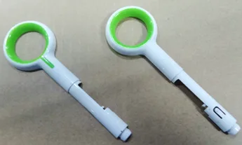 Two white and green molded handle assemblies