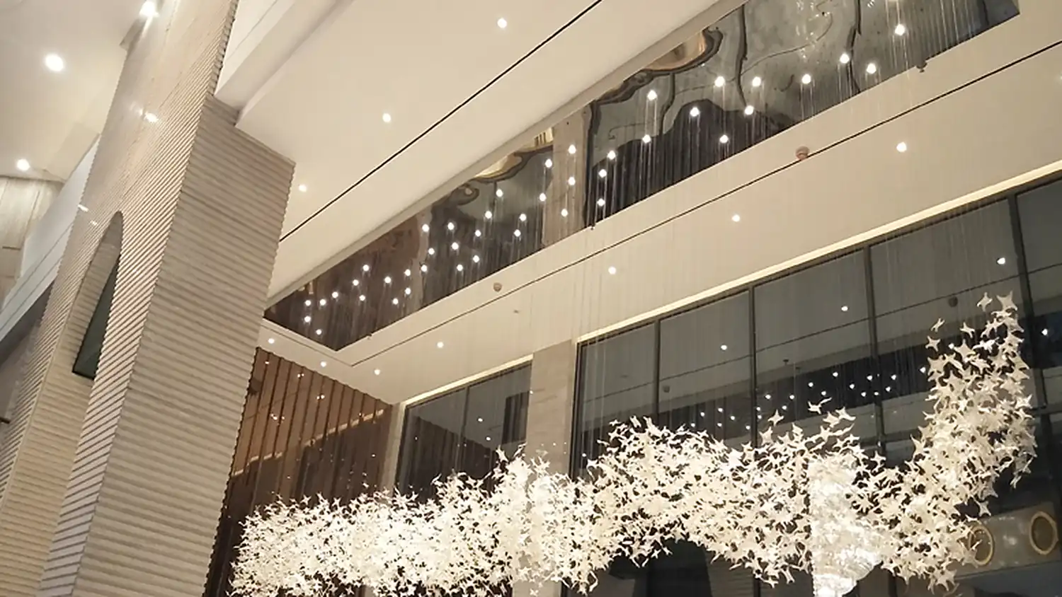White leaf light installation running the length of a double height hotel lobby