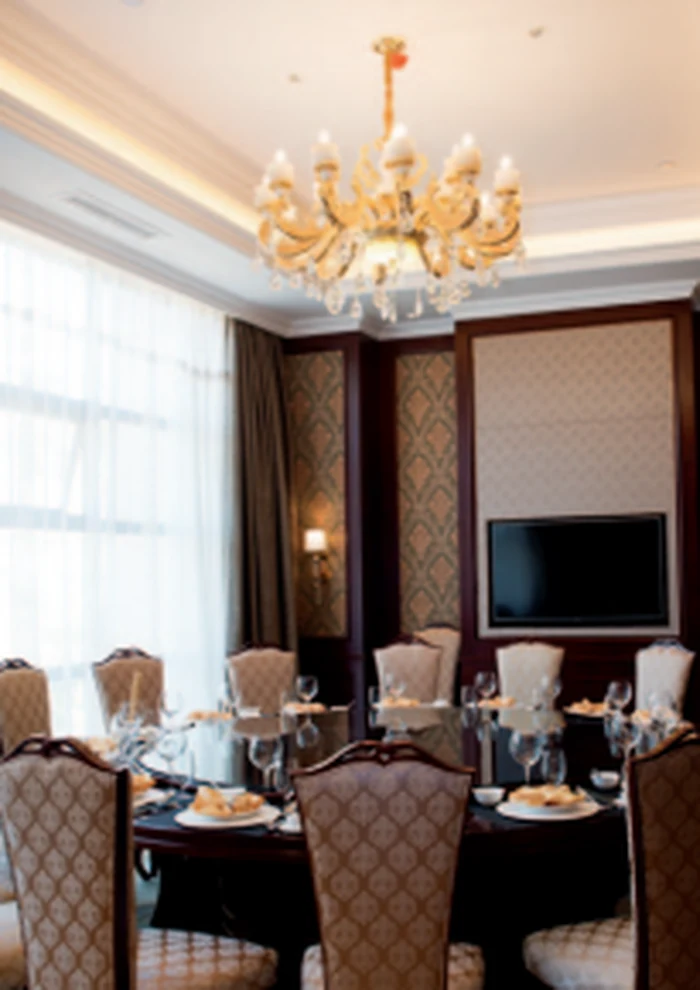 Gold chandelier over a laid banquet table in a hotel function room
