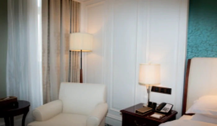 Floor lamp beside an armchair in a hotel guest room