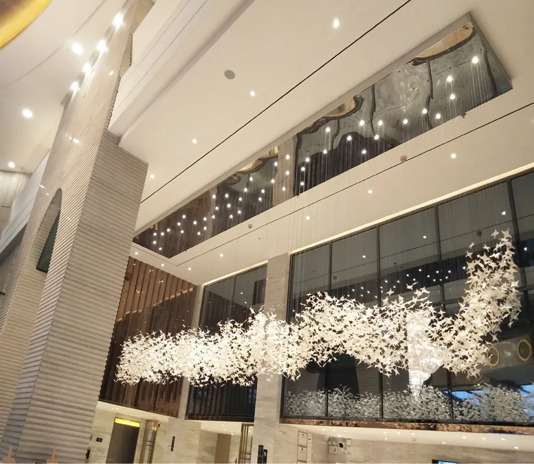 Long white leaf light installation running through a double height hotel lobby