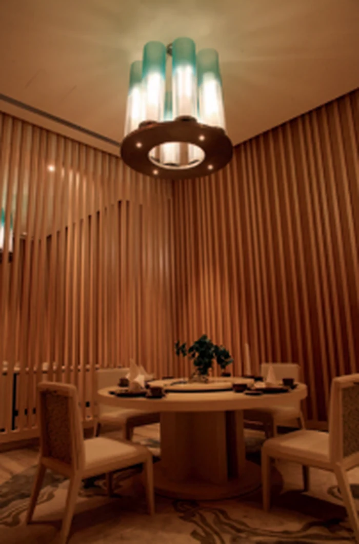 Green glass ring pendant above a round table in a private dining room