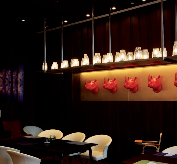Row of glass jar pendant lights above a restaurant bar counter