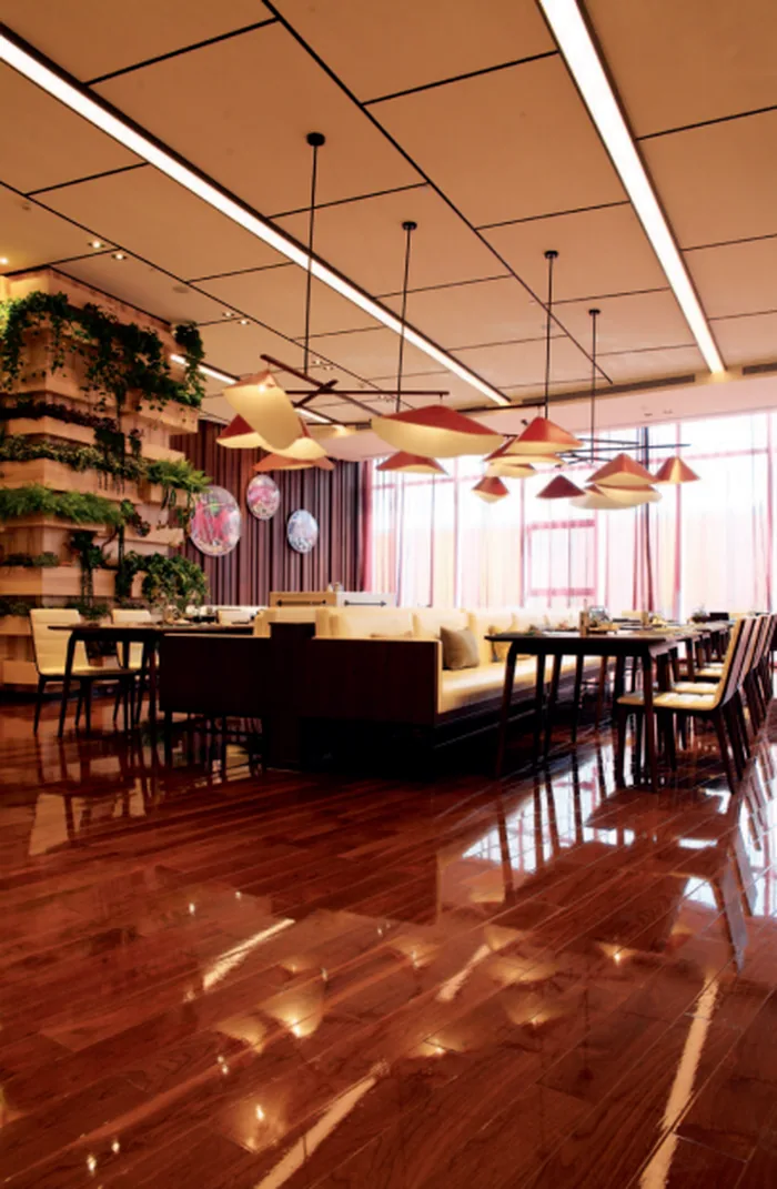Cluster of red and cream pendant lights over a restaurant dining area