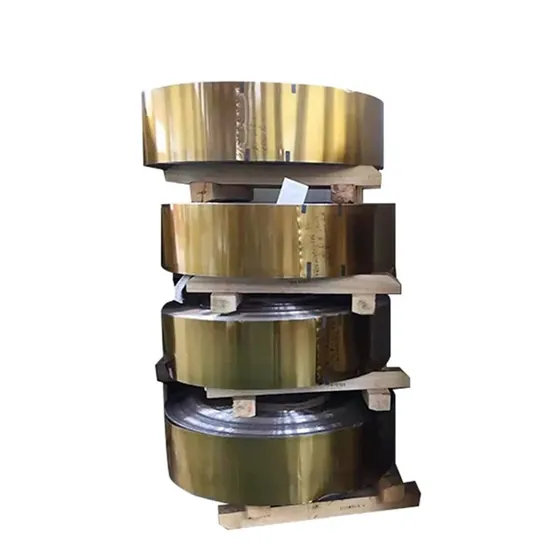 Stack of golden-colored metal strip coils resting on wooden pallets against a white background