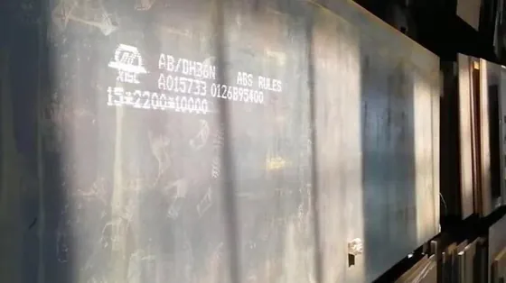 Stack of large metal steel plates with white stenciled specifications on the surface