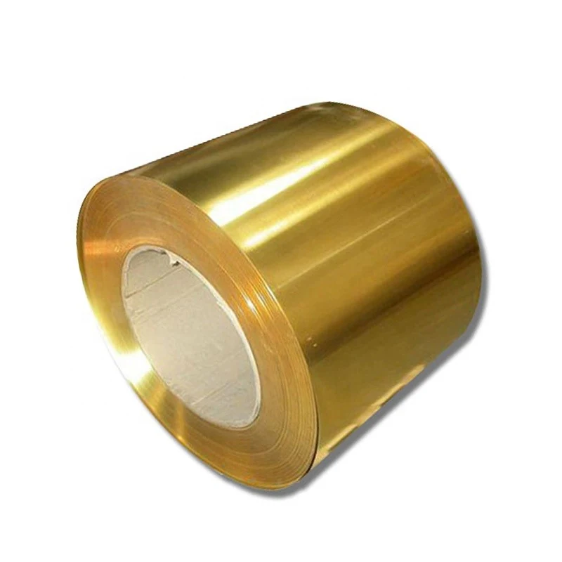 Coil of shiny golden brass strip wound around a white cylindrical core on a plain white background