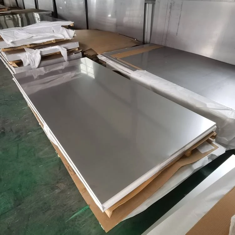 Stacks of large polished metal sheets on wooden pallets with cardboard separators in a warehouse