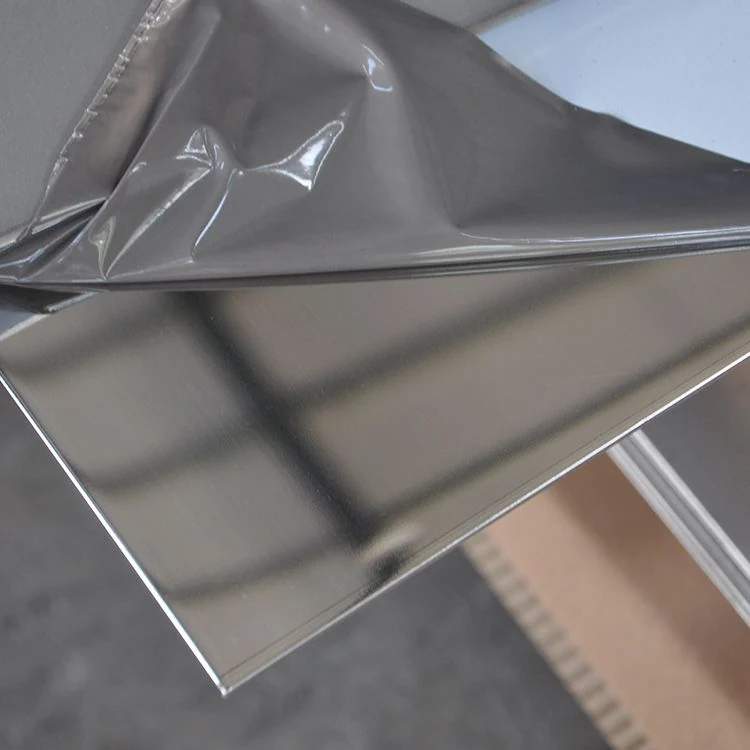 Brushed metal sheet with peeling gray protective film on a workshop floor