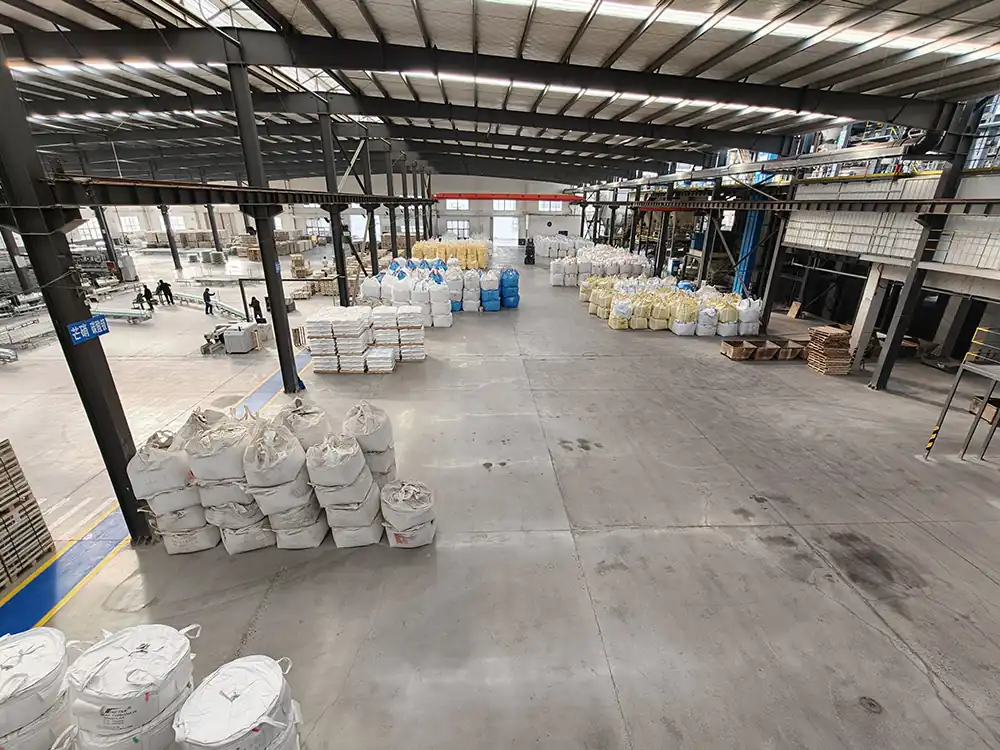 Bagged quartz sand and batch materials staged in the Jinhao raw material warehouse