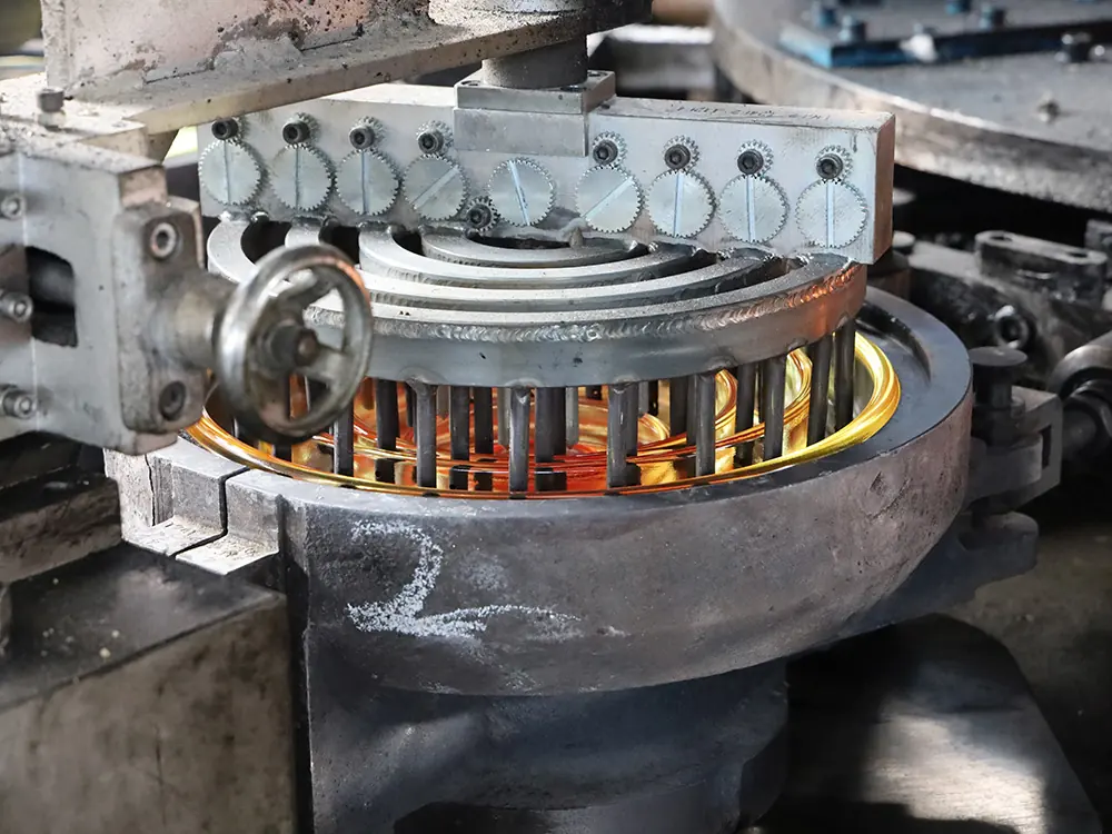 Rotating press forming a toughened glass insulator shell from a molten glass gob