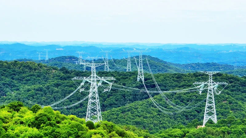 Ultra high voltage transmission towers crossing forested hills on the Longdong to Shandong DC line