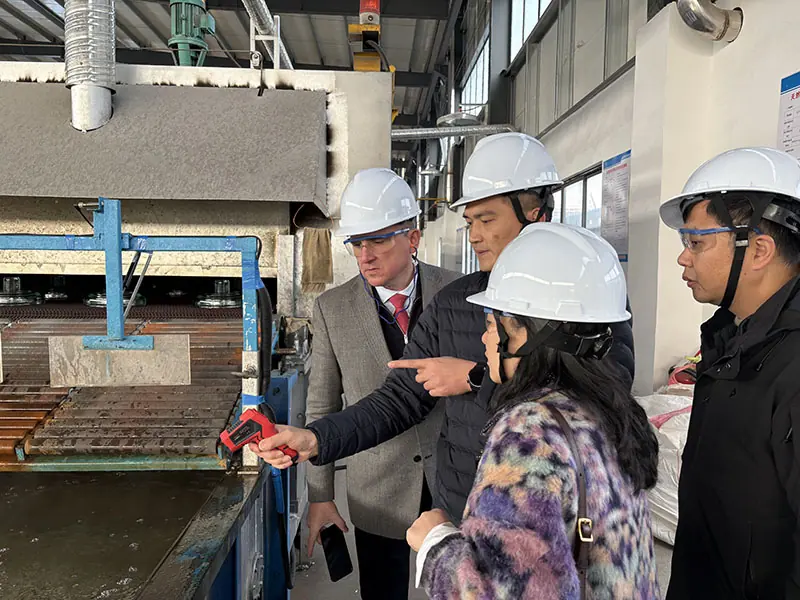 Pradex engineers inspecting toughened glass insulator production equipment at the Jinhao plant