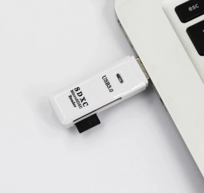 White USB 3.0 SD and microSD card reader plugged into a laptop