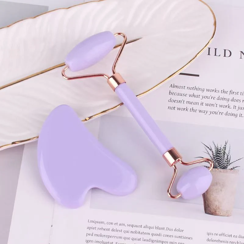 Set of two natural jade tools: Gua Sha scraper and jade roller laid out on a white surface
