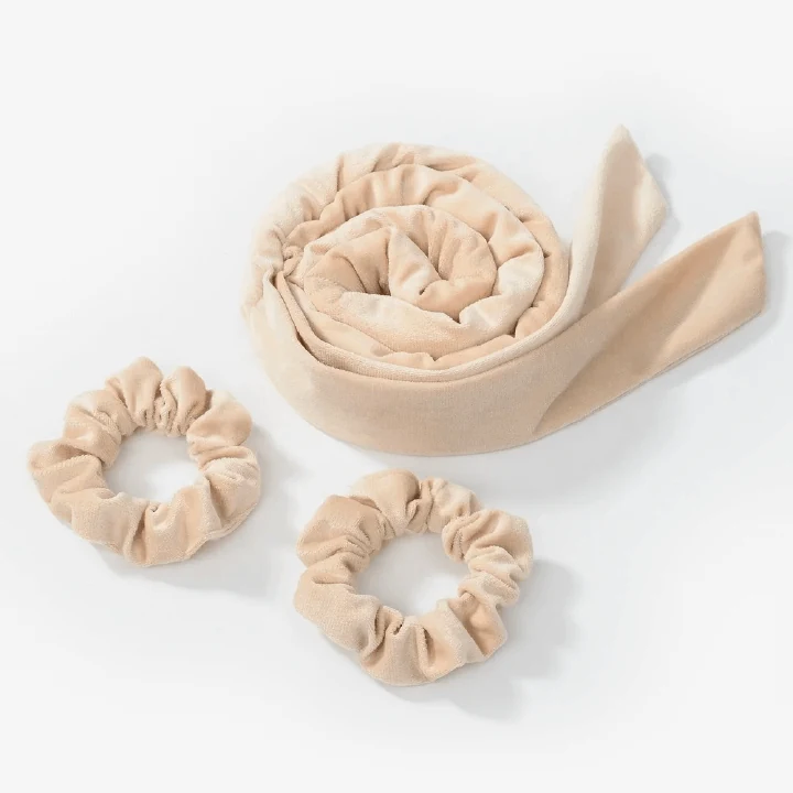 Set of flexible velvet covered heatless hair curlers laid out flat in beige