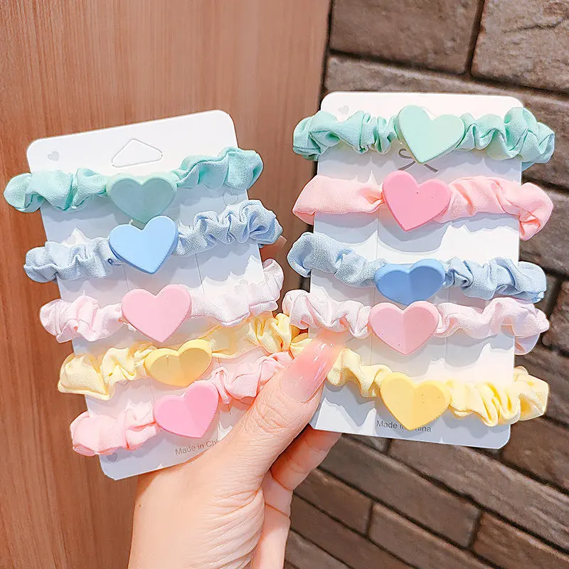 Three fabric hair ties laid out flat in different custom colours and shapes