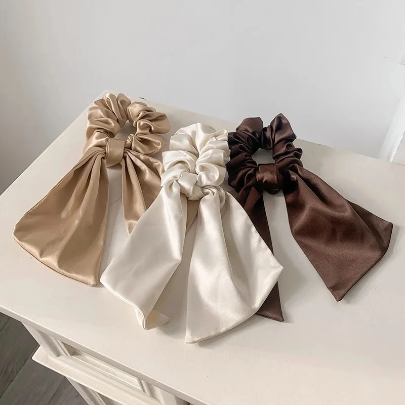 Set of silk satin scarf scrunchies laid out flat with plush inner core visible