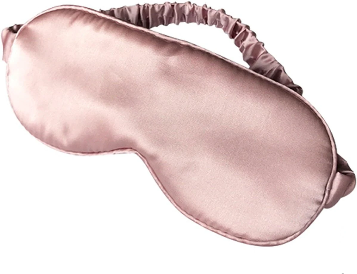 Silky sleep eye mask with elastic strap laid flat, showing satin face and elastic back