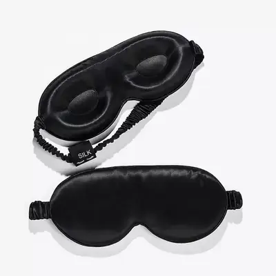 Silk sleep mask worn on a face, demonstrating the zero-pressure fit and light-blocking performance
